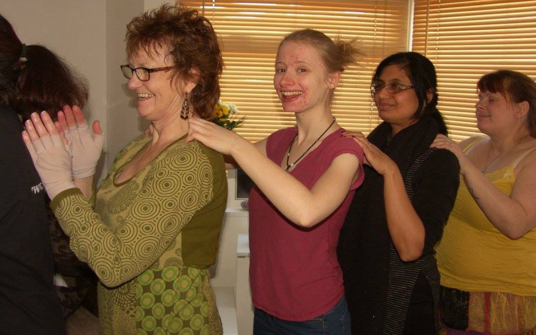 4 women in a line with hands on each others shoulders