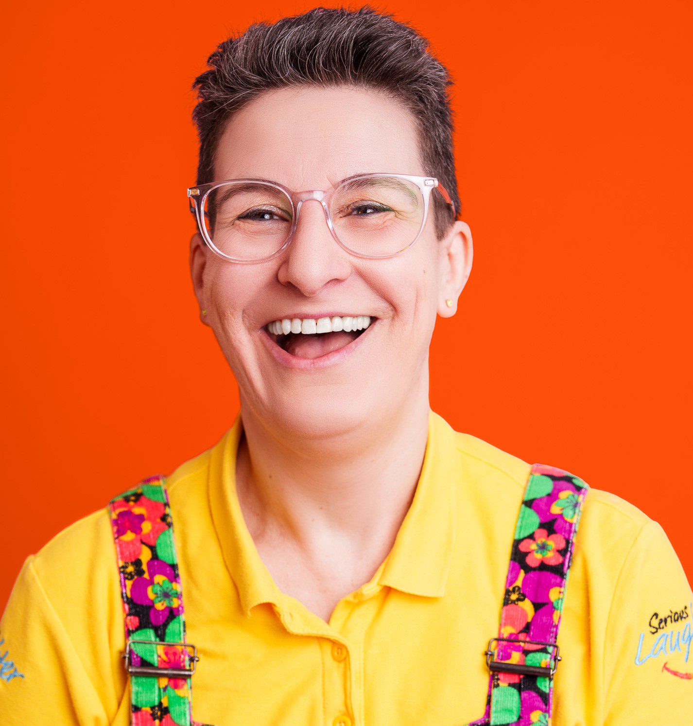 Woman smiling with short dark brown hair and yellow tshirt